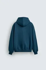 Sudadera con capucha de corte relajado, confeccionada en tejido de algodón con interior perchado. Presenta mangas largas, bolsillo frontal tipo canguro y terminaciones en rib.
