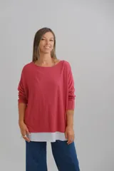 Sweater de punto color rojo con diseño de doble capa, que incluye una base inferior en color blanco. Presenta un corte amplio, escote redondo y mangas largas con detalles en hilo plateado en los bordes.