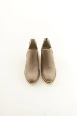 Botinetas de cuero negro, de diseño clásico con cierre en la parte trasera y costuras visibles en la suela.