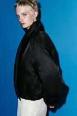 Chaqueta bomber acolchada de Zara Woman Collection, color azul marino, con cuello envolvente de solapa, manga larga con frunces y puños elásticos. Presenta bolsillos laterales y bajo con elástico interior.