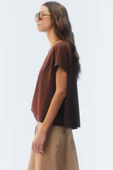 Remera negra de corte evasé y largo corto, con escote redondo y mangas cortas.