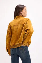 Campera tipo denim oversized en tono ocre lavado, con cierre frontal, bolsillos laterales y detalles de costura marcados. Presenta un diseño de corte holgado con puños y ruedo elásticos.