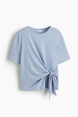 Top de punto suave color celeste, con cuello redondo, mangas al codo y detalle de tiras anchas para anudar en un lateral de la cintura.