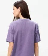 Remera de algodón color lila con efecto lavado, cuello redondo y mangas cortas. Presenta estampa frontal licenciada de The Rolling Stones con múltiples repeticiones del icónico logo de la lengua y detalles metalizados.