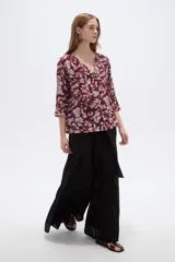 Blusa de viscosa bordó con estampado abstracto, escote en V con cuello tipo solapa y mangas 3/4, de corte holgado.