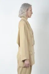 Chaqueta color beige de seersucker ligero con espalda abierta y doble botonadura.