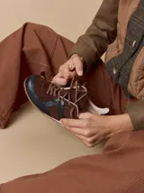 Championes de cuero en tonos bordó y rojo, con diseño de paneles combinados en gamuza y cuero texturizado. Presentan suela blanca con base dentada color caramelo y cordones jaspeados.