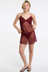 Camisón de encaje color bordó con tirantes finos regulables, escote en V y espalda baja. El pecho está forrado con semi transparencia.
