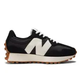 Championes urbanos New Balance modelo 327, con diseño retro inspirado en los años 70. Presentan un empeine de ante y malla en color negro, con el logo 'N' en gran tamaño en color blanco y una entresuela de espuma blanca con suela de goma dentada que se extiende hacia el talón.
