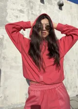 Conjunto deportivo de dos piezas en color rojo, compuesto por un buzo corto con capucha y un pantalón de jogging con cintura elástica.