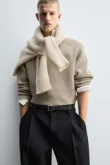 Jersey de punto con diseño boxy fit, cuello redondo y manga larga. Presenta una textura acanalada y acabados en rib en puños y ruedo.
