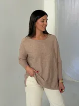 Sweater de punto color visón con diseño de trenzas horizontales, cuello redondo y mangas largas con puños acanalados.