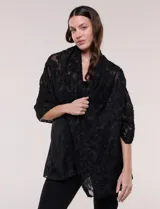 Pashmina rectangular negra con textura, bordados florales en relieve de efecto deshilachado y ligera transparencia.