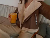 Campera tipo gamulán de cuerina color beige con interior y detalles en corderito blanco. Presenta corte biker, cierre frontal diagonal, bolsillos laterales con cierre y puños con vuelta de corderito.
