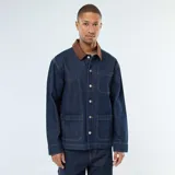 Chaqueta de denim azul oscuro con cuello de pana en color marrón, cierre frontal con botones metálicos, bolsillos frontales tipo parche y costuras a contraste.