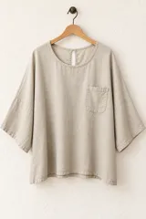 Remera de algodón color verde militar, de corte holgado, con mangas cortas amplias, cuello redondo y un bolsillo aplicado en el pecho.