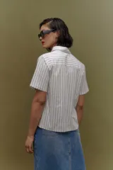 Camisa blanca con rayas verticales azul marino, de corte clásico, cuello camisero y manga corta.