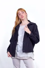 Campera negra alicrada con aplique de estampa de recortes de diario en la espalda.