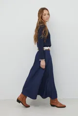 Falda larga de jean color azul oscuro con corte evasé y costuras con pespuntes a contratono. Presenta una cintura elástica para mayor comodidad.