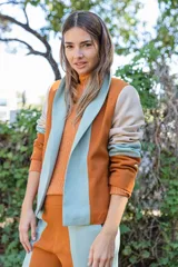 Chaqueta de corte sastre con diseño color block en tonos naranja, celeste y beige. Presenta solapas anchas, mangas largas y bolsillos laterales.