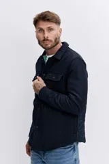 Campera tipo sobrecamisa de lana en color azul marino, con cuello clásico, cierre frontal con botones y bolsillos frontales con solapa. Presenta un forro interno en color verde.