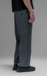 Pantalón de corte oversize color gris carbón, confeccionado en microfibra técnica. Presenta cintura elástica, bolsillos laterales, un bolsillo cargo con cierre de broche y sistema de elásticos con tancas en los tobillos para regular la apertura.