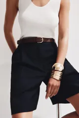 Cinturón de cuero marrón con textura granulada y hebilla metálica dorada de forma ovalada.