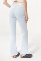 Jean celeste de tiro medio/alto, silueta levemente acampanada desde la rodilla, con tajo en el bajo y bordado floral en la pretina.