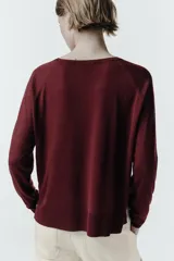 Jersey de punto negro con cuello redondo, manga larga y aberturas laterales en el bajo. Acabados en rib.