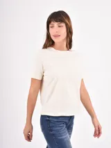 Remera básica de cuello redondo y manga corta, confeccionada en algodón color crema, con corte recto y ajuste cómodo.