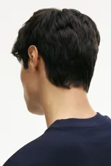 Remera de manga larga color azul marino, de punto de algodón de peso medio, con cuello redondo acanalado, hombros caídos, puños acanalados y bajo recto. Presenta un corte holgado.