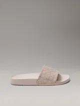 Ojotas de diseño anatómico con tira ancha superior estampada con el monograma de la marca. Presentan plantilla contorneada para mayor confort y suela de material sintético.