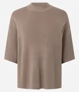 Blusa de punto de corte holgado, color negro, con cuello redondo elevado y mangas cortas amplias con sisa desplazada.