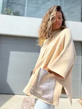 Saco tejido de punto en color crudo, con diseño holgado, mangas tres cuartos y bolsillos frontales grandes confeccionados en cuero metalizado plateado.