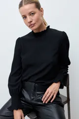 Blusa de textura rugosa con cuello alto con volados y mangas largas con puños elásticos en punto smock.