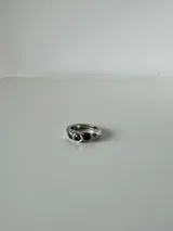 Anillo de acero quirúrgico con diseño de superficie irregular y texturizada, de estilo abierto y ajustable.