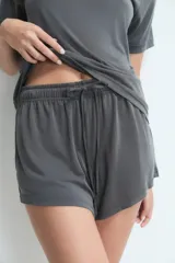 Short de descanso color gris, con cintura elástica y cordón ajustable. Presenta un diseño holgado y cómodo.