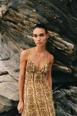 Vestido midi de broderie en tonos mostaza y marrón, con escote en V, tirantes finos ajustables, abertura cut-out en la cintura y espalda con nido de abeja elástico.