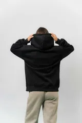 Campera deportiva con capucha de corte oversize, confeccionada en tejido suave con interior forrado en piel sintética. Presenta cierre frontal completo, bolsillos laterales y capucha amplia con cordones largos ajustables.