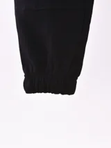 Pantalón de jogging negro con bolsillos cargo laterales, cintura elástica ajustable con cordón y puños elásticos.