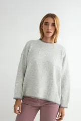 Buzo de tejido de punto con textura jaspeada en color gris claro. Presenta cuello redondo, mangas largas y detalles de terminación en color gris oscuro en el cuello, puños y ruedo.