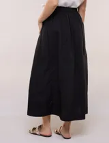 Falda midi evasé de algodón color negro, con tiro alto, pretina con elástico posterior, abotonadura frontal con botones carey y bolsillos laterales.