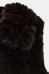 Chaleco de cuello solapa y manga sisa, confeccionado en tejido sintético efecto pelo de color bordó. Cuenta con bolsillos de vivo en el delantero y cierre frontal con ganchos metálicos ocultos.