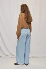 Jean wide leg blanco de tiro medio, con calce amplio y detalle de flores bordadas en los laterales.
