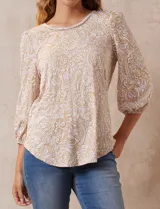 Blusa estampada color beige con cuello redondo calado y mangas 3/4 abullonadas con terminación elastizada.