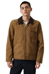 Campera de canvas color marrón con cuello de pana en contraste, cierre frontal completo, bolsillo en el pecho con solapa y bolsillos laterales inclinados.