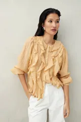 Camisa color durazno con volados en el frente, cuello y mangas 3/4 abullonadas.