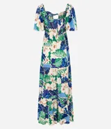 Vestido largo de viscosa con estampado tropical de flores blancas y hojas verdes y azules. Presenta escote cuadrado con lazo ajustable en el centro del busto y mangas cortas abullonadas. La falda es escalonada con volados.