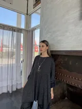 Sweater de punto color gris oscuro con detalles brillantes, de corte amplio y mangas largas con puños ajustados.