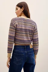 Cardigan cruzado de punto con estampado en zigzag en tonos lila, beige y negro, escote en V cruzado, mangas largas y lazo para atar en la cintura.